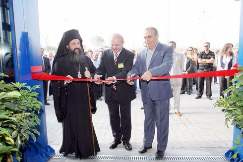 την κορδέλα κόβουν οι Ιωάννης Σελαλμαζίδης της Praktiker, ο Δήμαρχος Νέας Αλικαρνασσού Ευάγγελος Σισαμάκης υπό τις ευλογίες του επισκόπου Κνωσού Ευγενίου